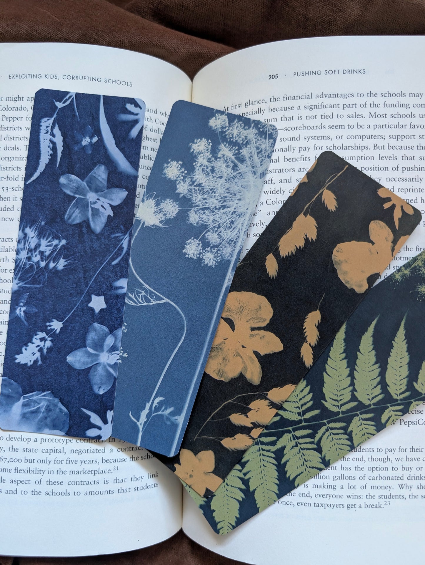 Four floral bookmarks on an open book with different patterns.